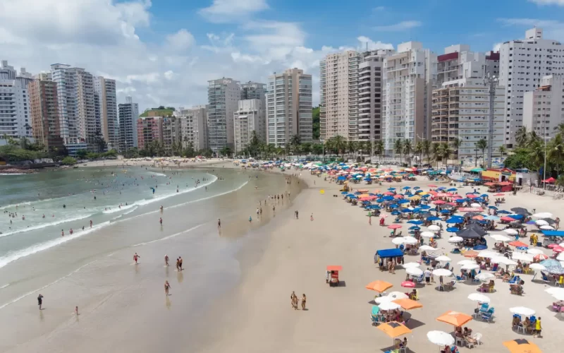 Praia no Guarujá em São Paulo com mar azul e faixa de areia extensa, uma dica de turismo no litoral Paulista