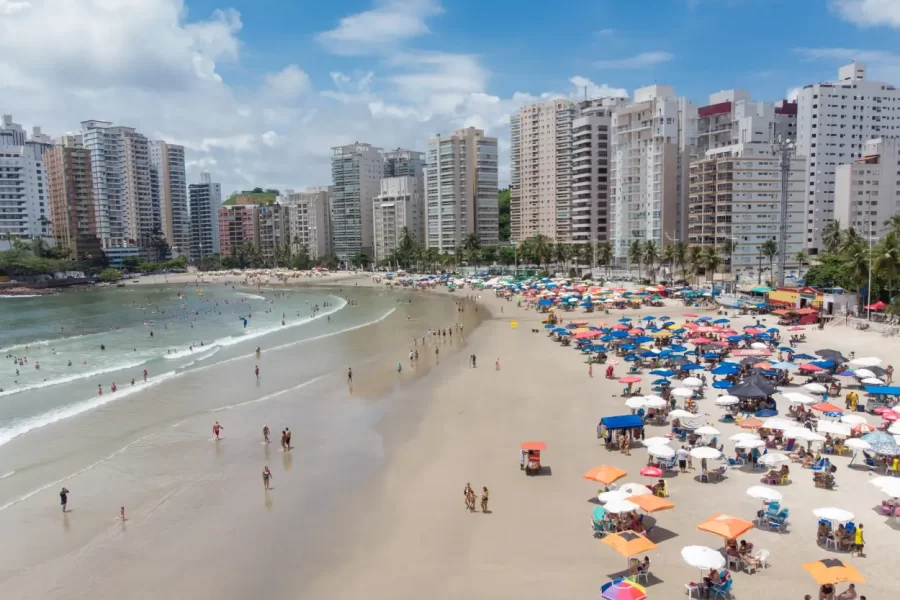 Praia no Guarujá em São Paulo com mar azul e faixa de areia extensa, uma dica de turismo no litoral Paulista