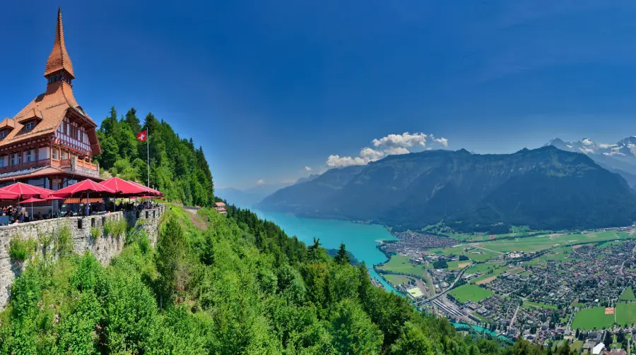 Áreas verdes e os Alpes ao fundo, destacando a paisagem natural e o charme da cidade em Interlaken, na Suíça 